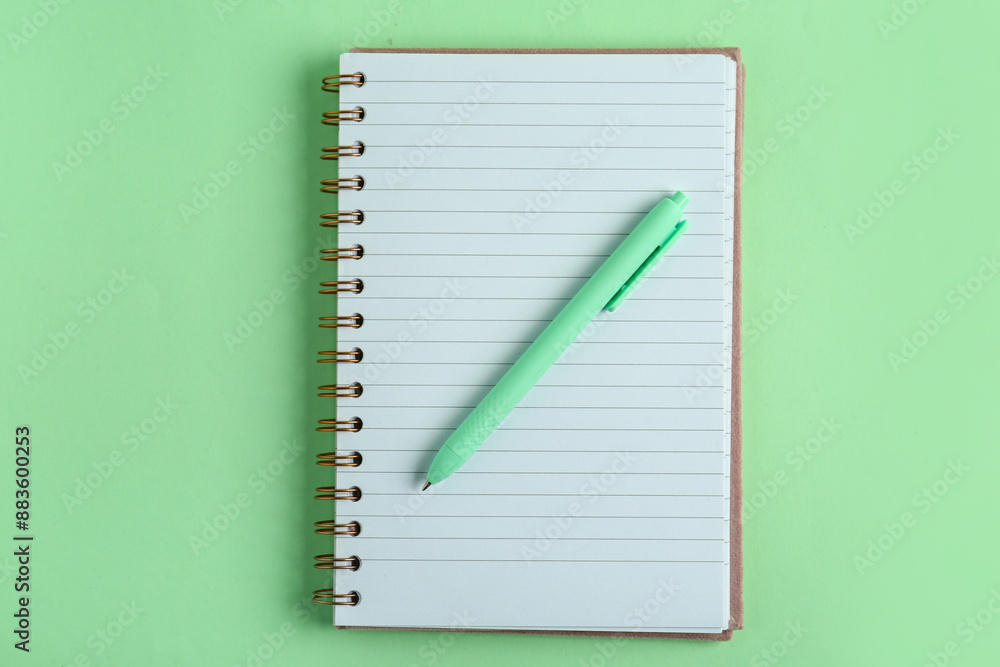 Pen with notebook on green background Pen with notebook on green background