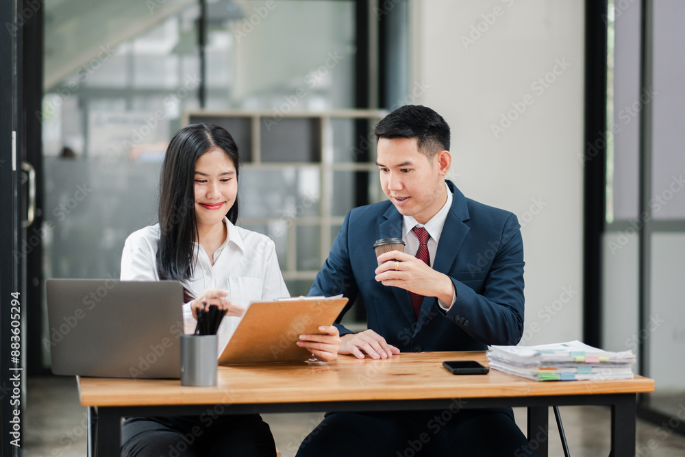 Two professionals discussing documents in a modern office setting, showcasing teamwork and business attire. Two professionals discussing documents in a modern office setting, showcasing teamwork and business attire.