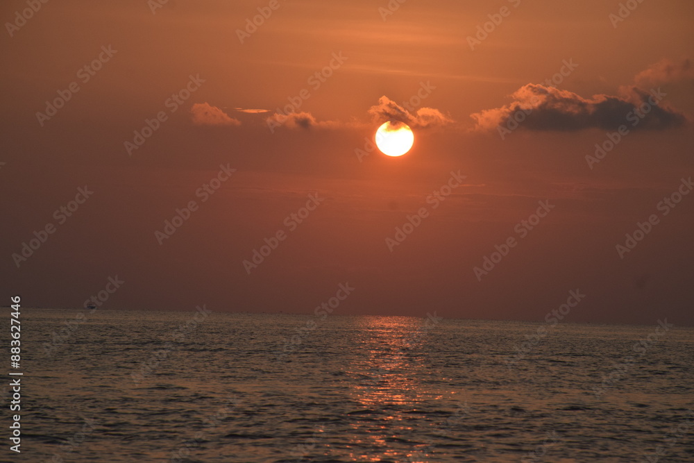 The sun looks like the moon before setting on the western horizon, has beauty with a dazzling orange light color The sun looks like the moon before setting on the western horizon, has beauty with a dazzling orange light color