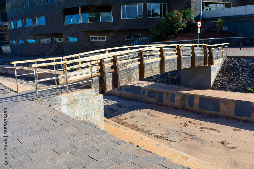 Wooden footbridge over canal in the city. Cityscape with pedestrian bridge