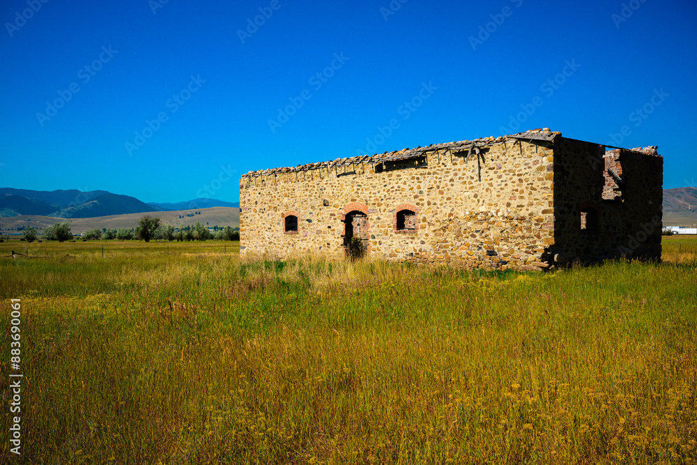 Historic rural landscape with old stone house and ruined walls on the prairie in Helena, Montana, USA Historic rural landscape with old stone house and ruined walls on the prairie in Helena, Montana, USA