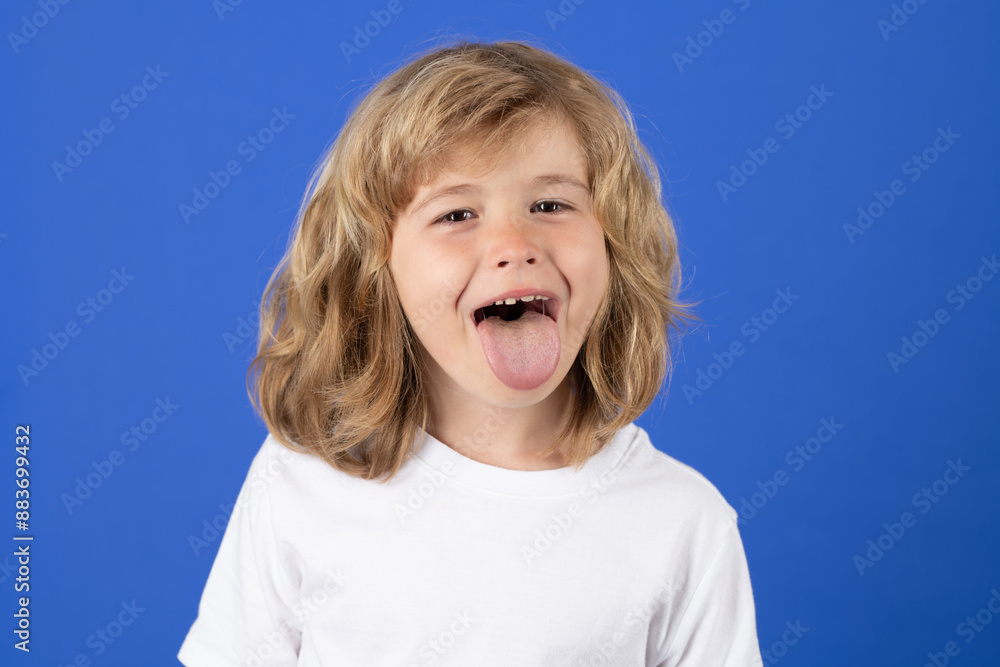 Child with tongue out on studio isolated background. Portrait of kid showing tongue. Funny boy stick tongue. Child with tongue out on studio isolated background. Portrait of kid showing tongue. Funny boy stick tongue.