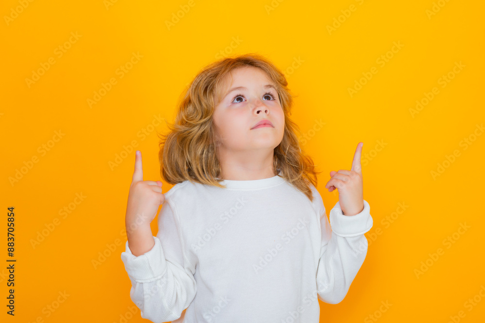 Kid Point Up Excited child pointing up on yellow isolated studio background. Shocked ...