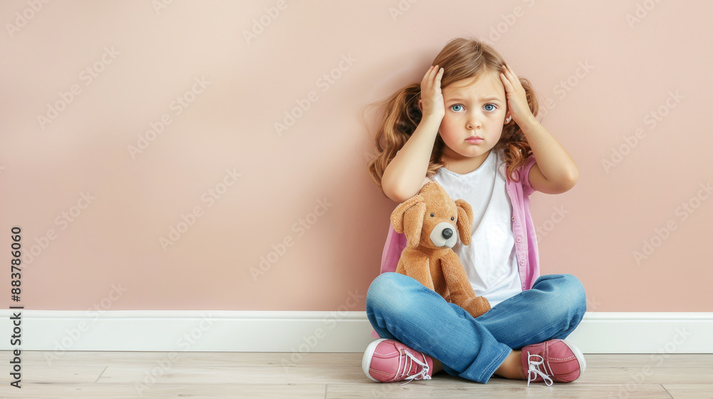 Autistic Little girl sits covering her head on floor against light wall. Copy space Autistic Little girl sits covering her head on floor against light wall. Copy space