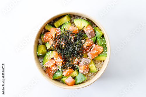 poke bowl with diced raw salmon fish and avocado on sushi rice in paper container.