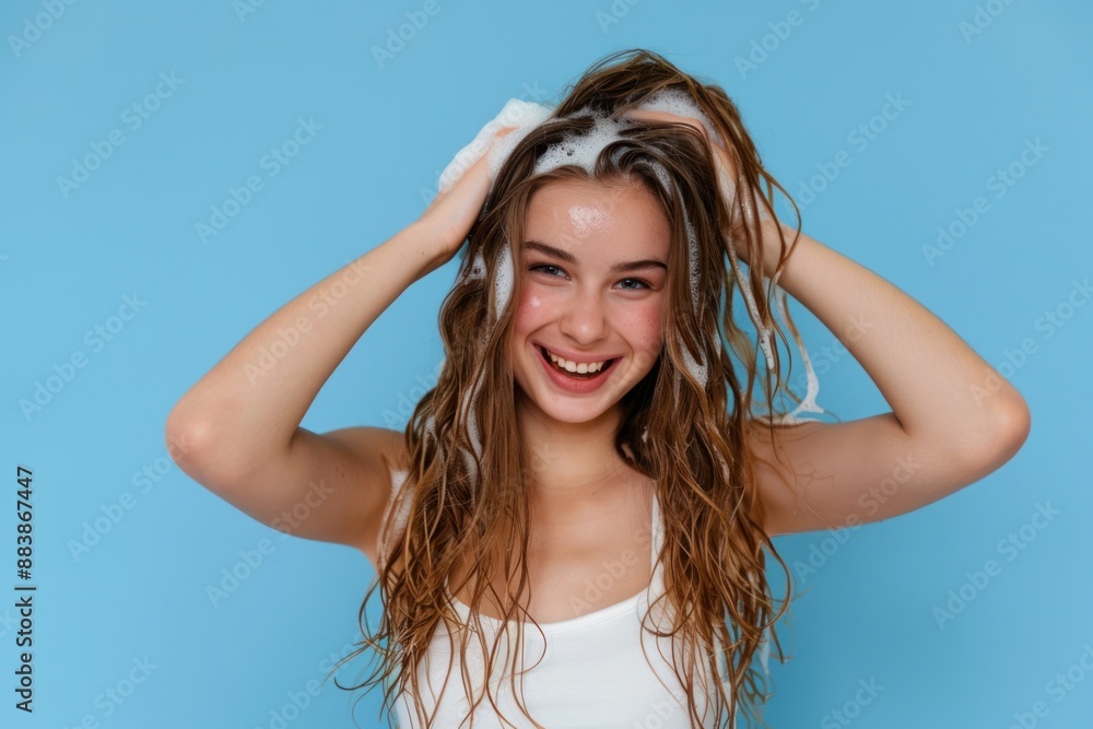 Attractive Young Woman Shampooing Her Hair Isolated on blue background Attractive Young Woman Shampooing Her Hair Isolated on blue background