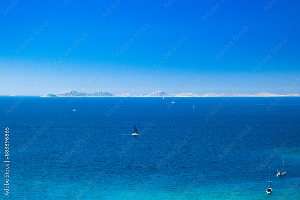 Adriatic seascape, panoramic view from Murter island, sailing boats and yachts on blue sea, Kornati archipelago in background, Croatia