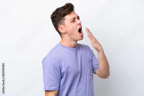 Young handsome Brazilian man isolated on white background yawning and covering wide open mouth with hand