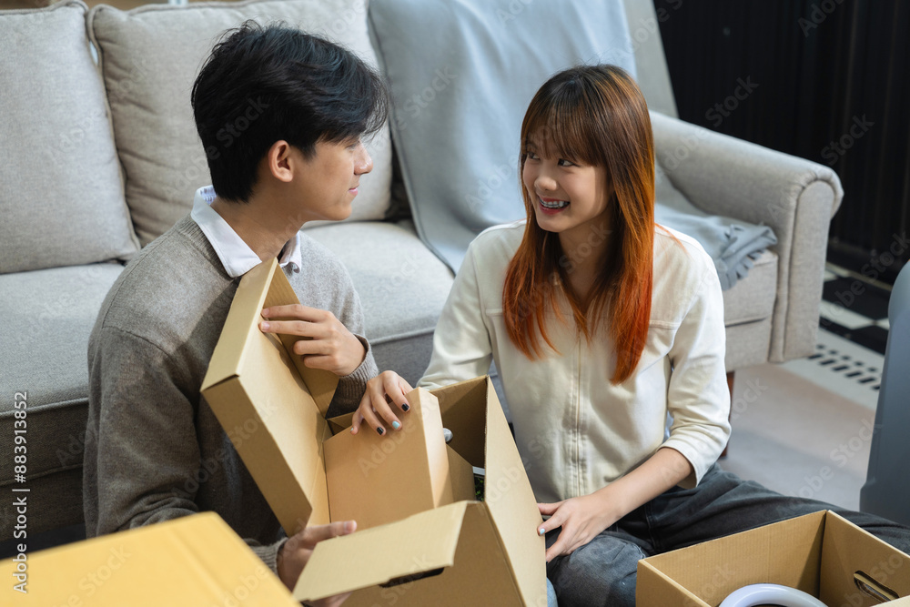 young couple helps put things in boxes and prepares, smiling happy moving to a new house. young couple helps put things in boxes and prepares, smiling happy moving to a new house.