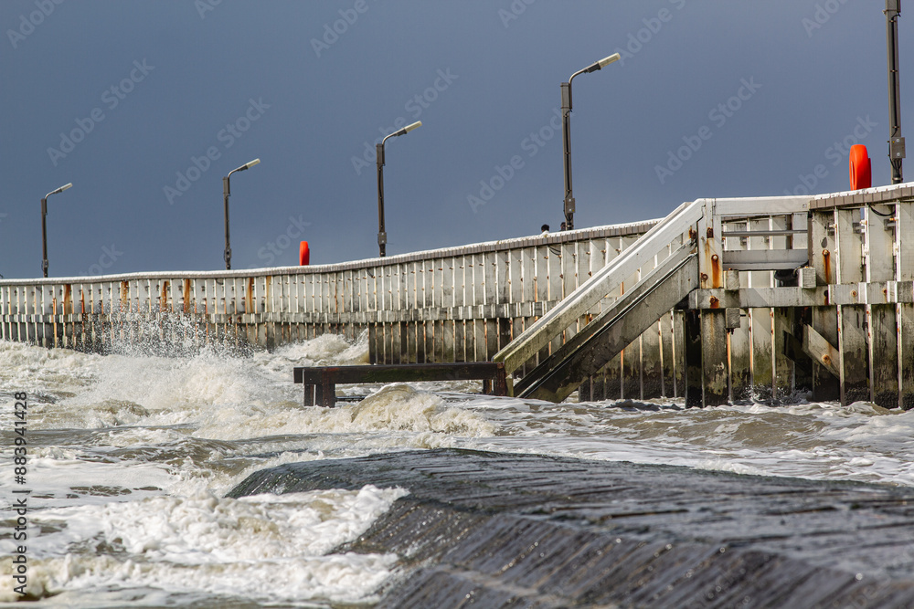 Beautiful seascape : North Sea waves rolling onto wave breaker and old wooden pier Beautiful seascape : North Sea waves rolling onto wave breaker and old wooden pier