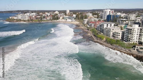 Aerial drone pullback reverse view from above Cronulla rock pools heading north along Prince Street and Cronulla beach in the Sutherland Shire, South Sydney, NSW Australia on a sunny morning on 14 Jul photo