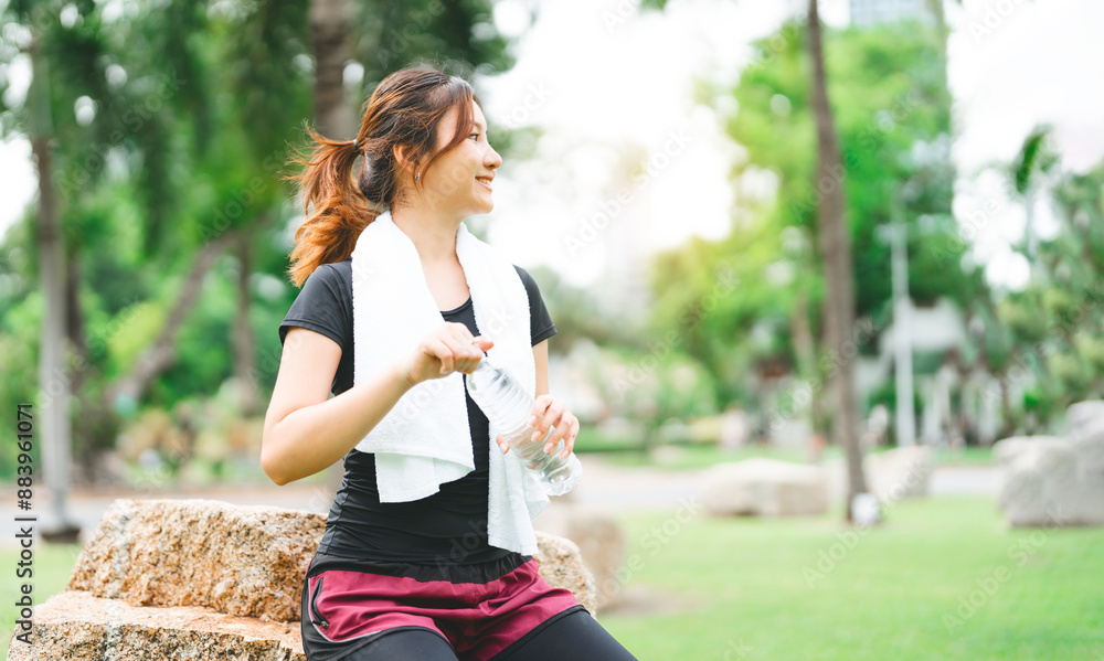 Asian woman exercise and fitness at outdoor with pet bottle drinking water and towel Asian woman exercise and fitness at outdoor with pet bottle drinking water and towel