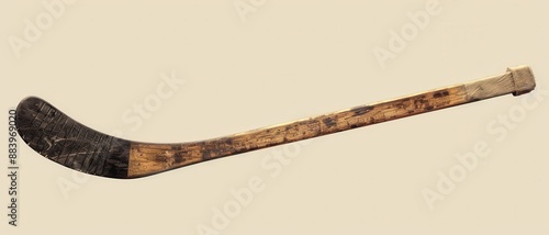 An old wooden hockey stick with black tape.