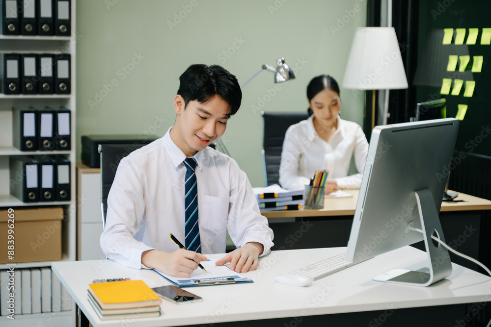 Young businessman working at office with laptop, tablet and taking notes on the paper.. Young businessman working at office with laptop, tablet and taking notes on the paper..