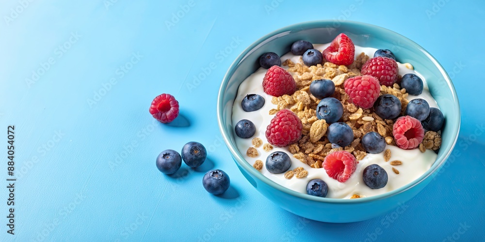 Bowl of yogurt and granola with fresh blueberries and raspberries on blue background, yogurt, granola, blueberries Bowl of yogurt and granola with fresh blueberries and raspberries on blue background, yogurt, granola, blueberries
