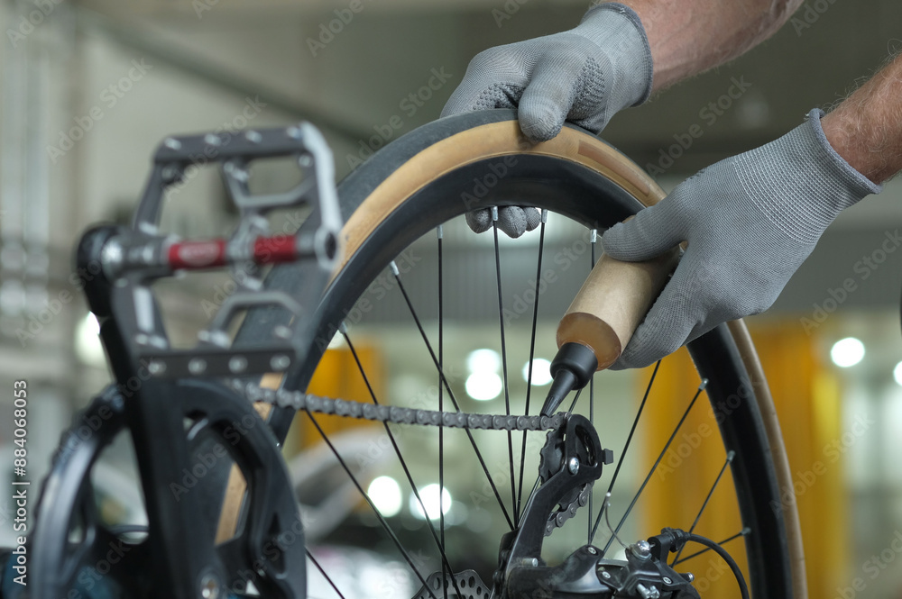 Bike maintenance at the service center. An auto mechanic lubricates the friction parts and structural elements of a bicycle. Bike maintenance at the service center. An auto mechanic lubricates the friction parts and structural elements of a bicycle.