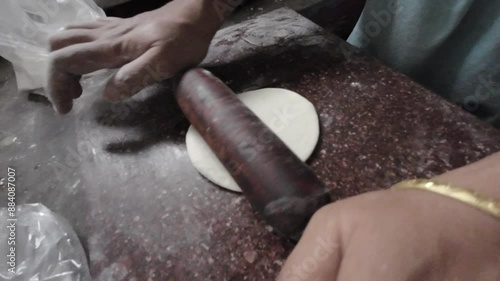 Indian woman hand's rolling dough making puri. Rolling and kneading dough for flatbread baking, closeup on hands. Making puri with belan in Indian 4k footage