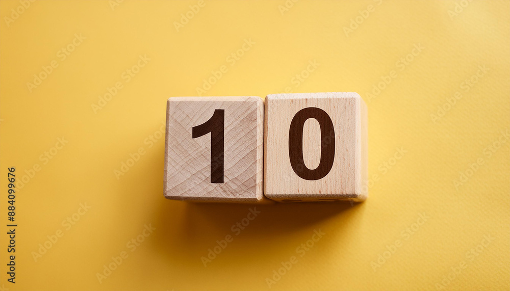 Wooden cubes with number 10 on isolated yellow backdrop. Wood blocks. Close-up. Flat lay Wooden cubes with number 10 on isolated yellow backdrop. Wood blocks. Close-up. Flat lay