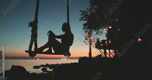Foto Girl sit on swing enjoy evening sea coast sunset landscape