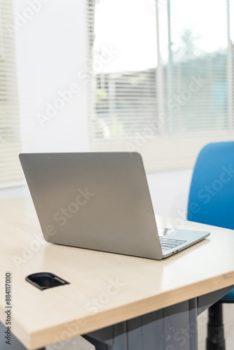 Wallpaper Mural An empty desk in a minimalist office setting, featuring a blank workspace, large windows, a laptop, and a blue office chair against a white wall background, ideal for product montages. no people Torontodigital.ca