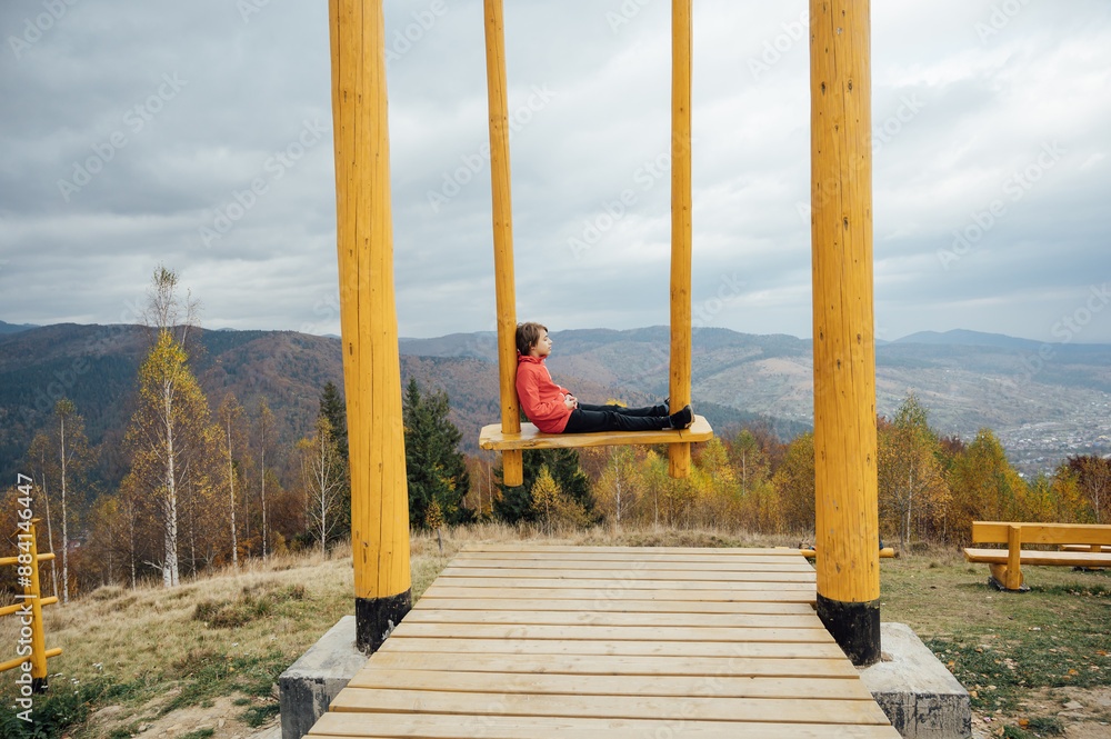 Boy in the mountains on a big swing Boy in the mountains on a big swing