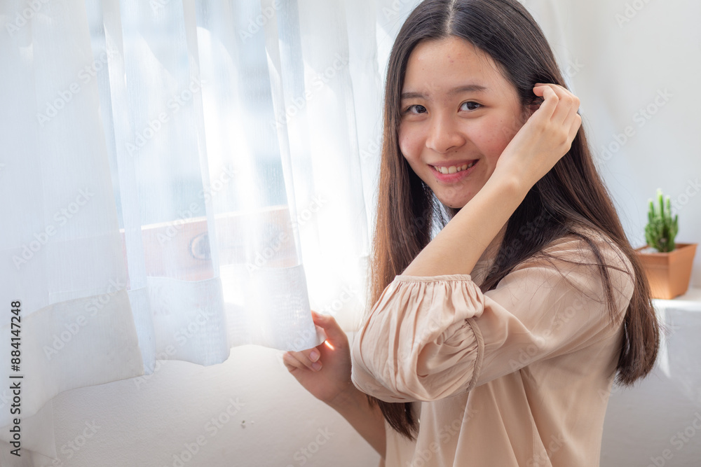 Beautiful smiling asian office woman in cozy room with window and curtain in back Beautiful smiling asian office woman in cozy room with window and curtain in back