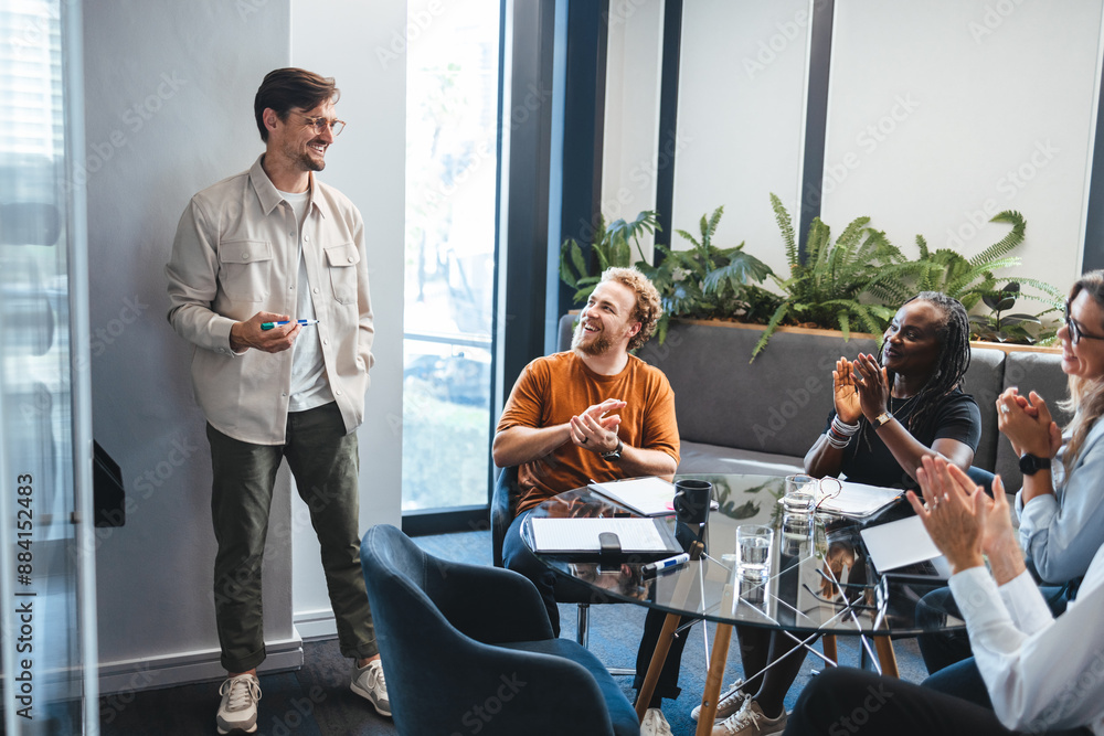 © Jacob Lund - Collaboration and success: Business team applauding a colleague for his contribution to the company