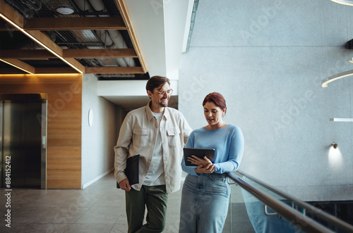Business professionals discussing using a a tablet in a modern office