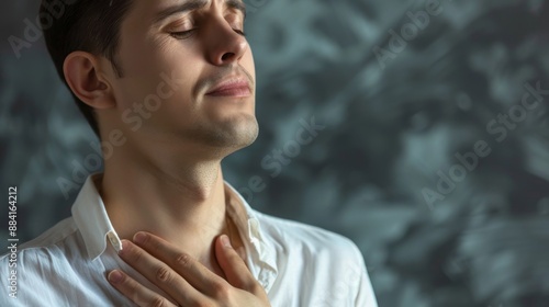 Young Man Experiencing Throat Pain Against Abstract Background © Oksana Smyshliaeva