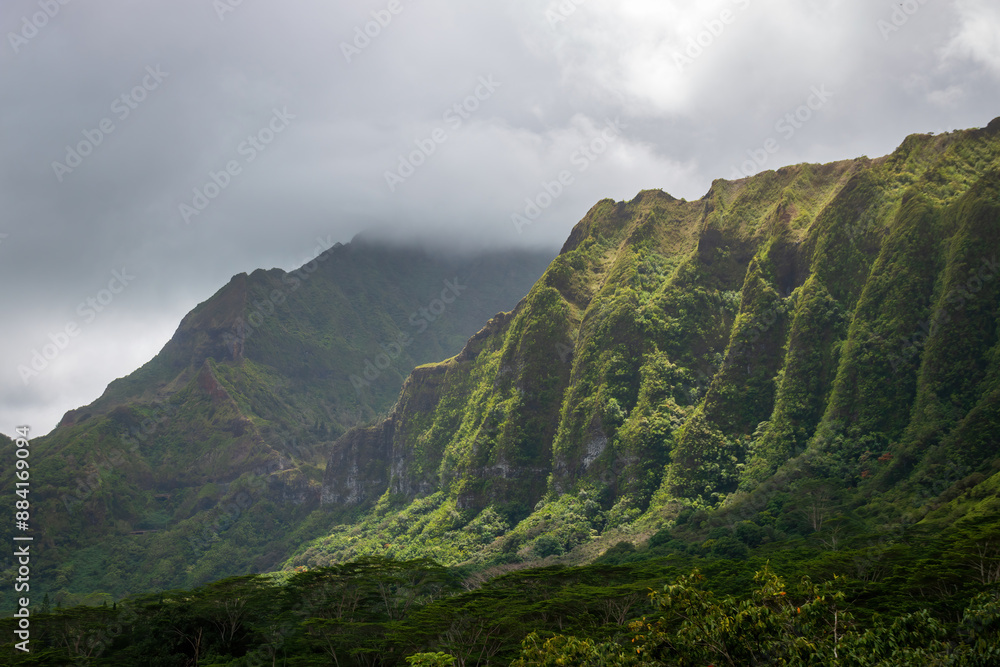 Scenic view of landscape with green mountains seen from Ho'omaluhia Botanical Garden on the Hawaiian Island of Oahu, USA against cloudy sky