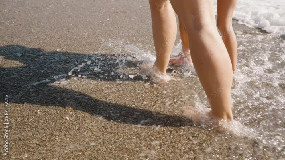 A Mother and Daughter Playfully Running Through the Shallow Water on the Beach. Their Feet Kick Up Splashes, Capturing a Joyful and Energetic Moment in the Sunlit Sand. A Mother and Daughter Playfully Running Through the Shallow Water on the Beach. Their Feet Kick Up Splashes, Capturing a Joyful and Energetic Moment in the Sunlit Sand.