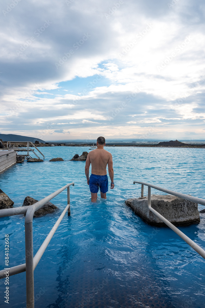 Fototapeta premium Man relaxing in the blue waters of a geothermal lagoon in Iceland