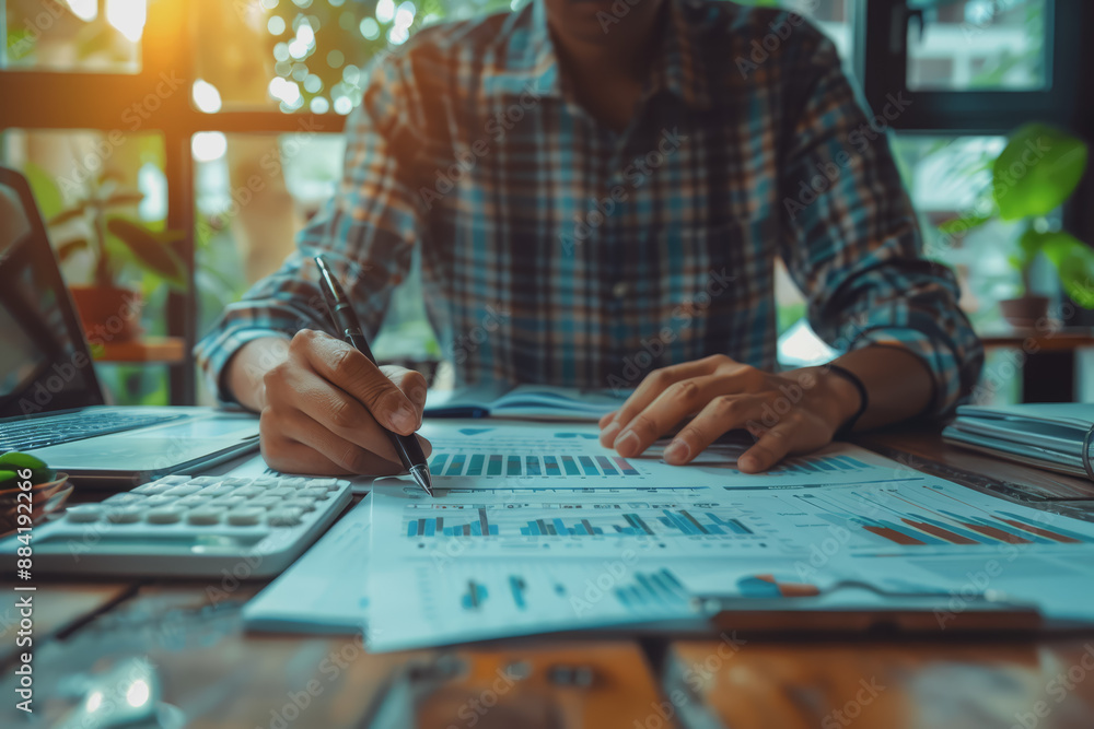 Fototapeta premium Hand man doing finances and calculate on desk about cost at home office.