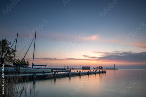 Sunrise on the shore and harbor of a lake in summer. Colorful sky with a wide view of the Horiont. Nature landscape at Tihany marina, Balaton, Lake Balaton, Siófok, Hungary