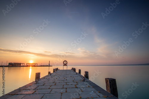 Sunrise on the shore and harbor of a lake in summer. Colorful sky with a wide view of the Horiont. Nature landscape at Tihany marina, Balaton, Lake Balaton, Siófok, Hungary photo