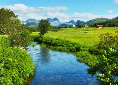 Landscape, countryside and nature with mountain, river and green trees in Norway for eco friendly. Environment, earth and water with grass, blue sky and plants for travel, ecology or sustainability