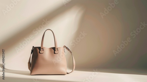 Simple photo of a beige leather bag highlighted by a beam of light on a neutral background
