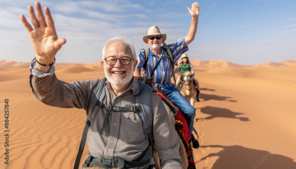 Two men on camels in the desert, one of them is waving Two men on camels in the desert, one of them is waving