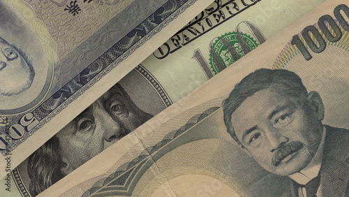 фотографія Portrait of the US President on the dollar bill peeks out from underneath the Japanese yen notes