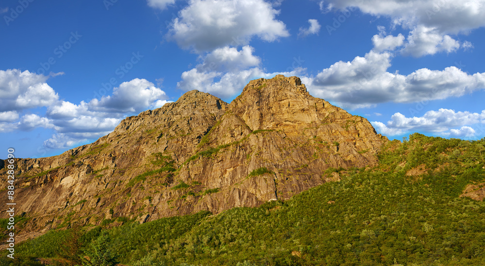 Mountain, outdoor and clouds in blue sky in nature by journey for travel destination in Norway. Background, landscape and hill peak for tourism vacation, holiday or trip to landmark in countryside. Mountain, outdoor and clouds in blue sky in nature by journey for travel destination in Norway. Background, landscape and hill peak for tourism vacation, holiday or trip to landmark in countryside.