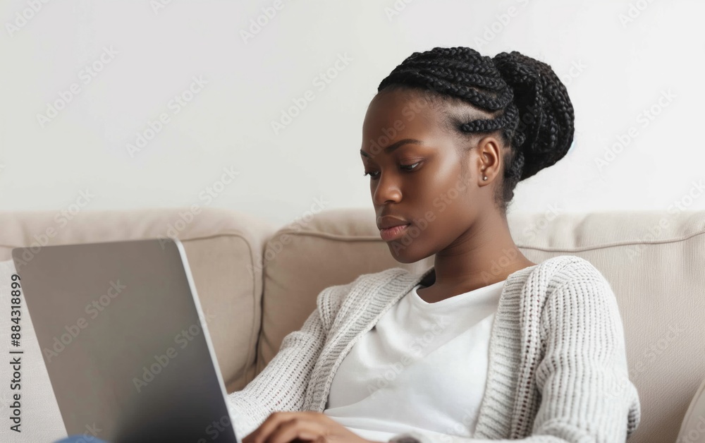 A serious woman working on her laptop at home, focusing on productivity and remote work, ideal for themes of business, technology, and home office. A serious woman working on her laptop at home, focusing on productivity and remote work, ideal for themes of business, technology, and home office.