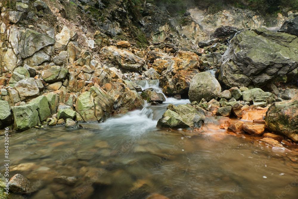 Naklejka premium Rushing Waters Over Vibrant Rocks