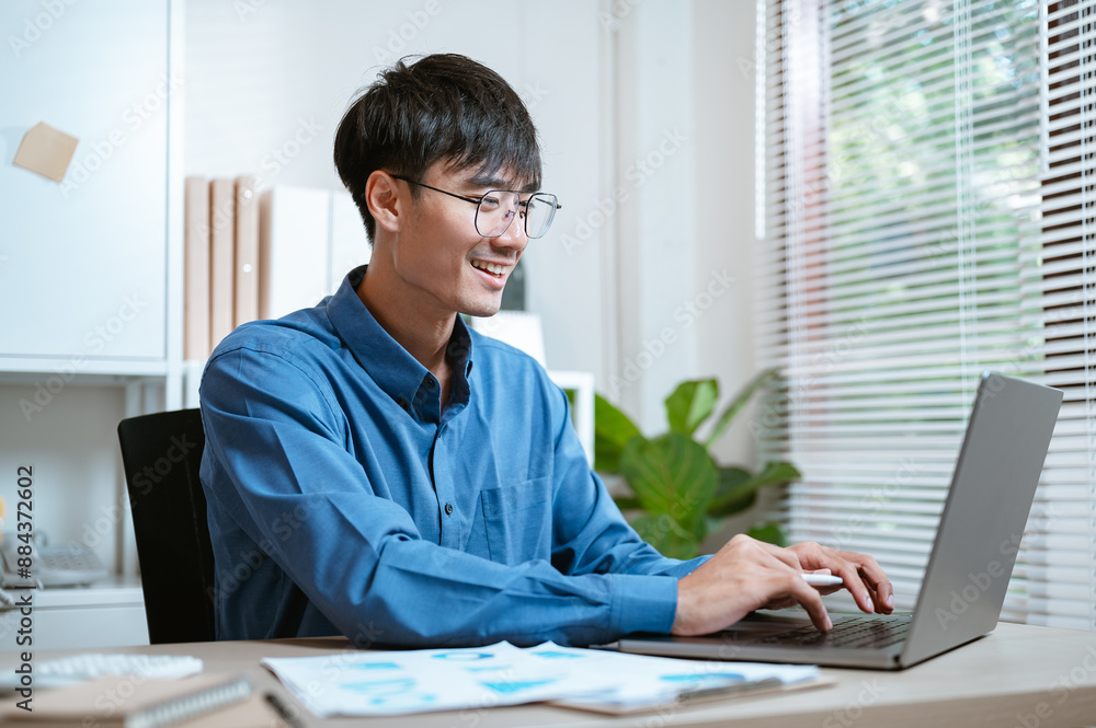 freelance, reading, communication, college, job, learn, lesson, manager, school, studying. A man wearing glasses is typing on a laptop computer. He is looking at the screen with a serious expression. freelance, reading, communication, college, job, learn, lesson, manager, school, studying. A man wearing glasses is typing on a laptop computer. He is looking at the screen with a serious expression.