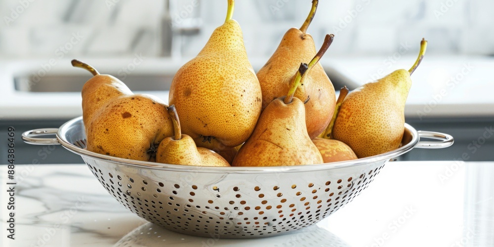 Fresh pears arranged in a metal colander on a kitchen counter Fresh pears arranged in a metal colander on a kitchen counter