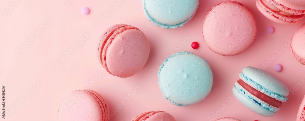 Fototapeta premium Four different colored macarons are displayed on a pink background.