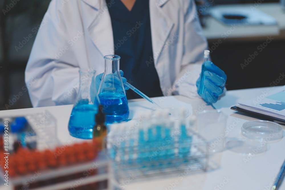 Group of dedicated scientist conduct chemical experiment in medical laboratory, carefully drop precise amount of liquid from pipette into test tube for vaccine drug or antibiotic development. Neoteric Group of dedicated scientist conduct chemical experiment in medical laboratory, carefully drop precise amount of liquid from pipette into test tube for vaccine drug or antibiotic development. Neoteric