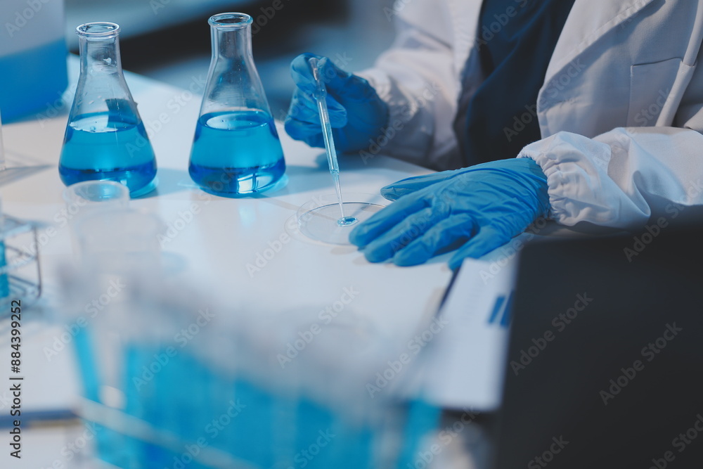Group of dedicated scientist conduct chemical experiment in medical laboratory, carefully drop precise amount of liquid from pipette into test tube for vaccine drug or antibiotic development. Neoteric Group of dedicated scientist conduct chemical experiment in medical laboratory, carefully drop precise amount of liquid from pipette into test tube for vaccine drug or antibiotic development. Neoteric
