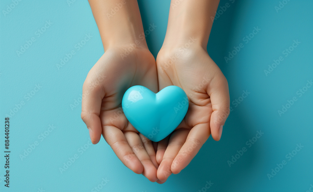 Obraz premium Hands holding a glowing blue heart symbolizing love and care.