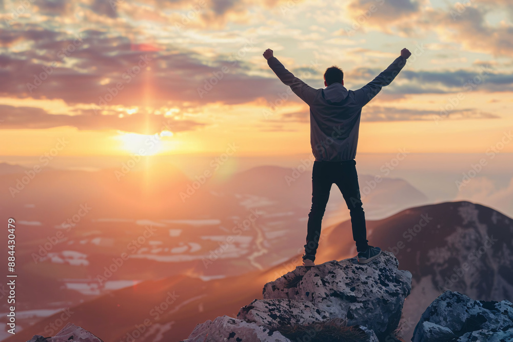 Obraz premium Man celebrating on a mountain peak at sunrise, symbolizing victory, achievement, and success