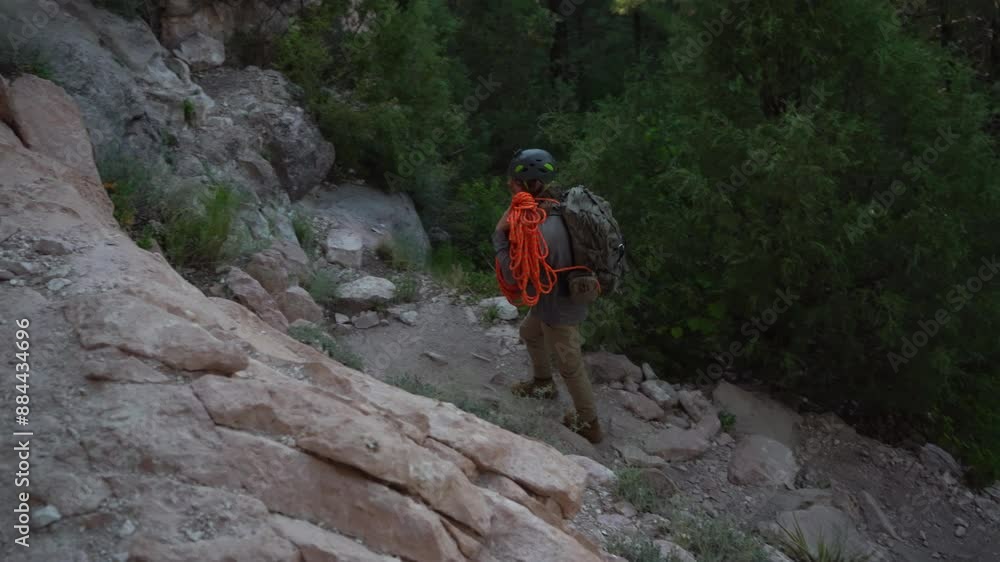 A rock climber heading to the cliffs with his rope and gear A rock climber heading to the cliffs with his rope and gear